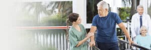 nurse walking with man using a walker
